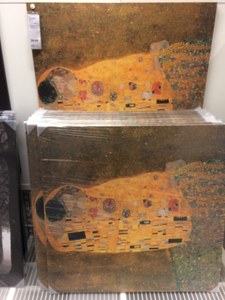 Kunstdrucke des Kusses von Gustav Klimt auf Leinwand in einem weißen Metallregal