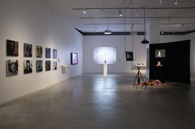 Ausstellungsansicht. Großer weißer Raum mit einigen Kunstwerken an der Wand.