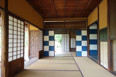 Innenraum eines japanischen Hauses. Zu erkennen sind viele geöffnete Schiebetüren.