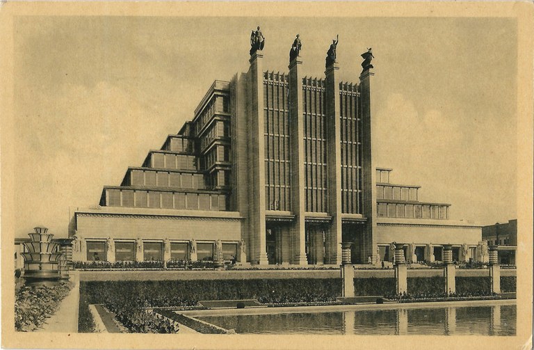 Monumentales, pyramidenartiges Gebäude. Der Eingang wird von vier hohen Pfeilern markiert auf deren Spitzen jeweils eine Statue steht.