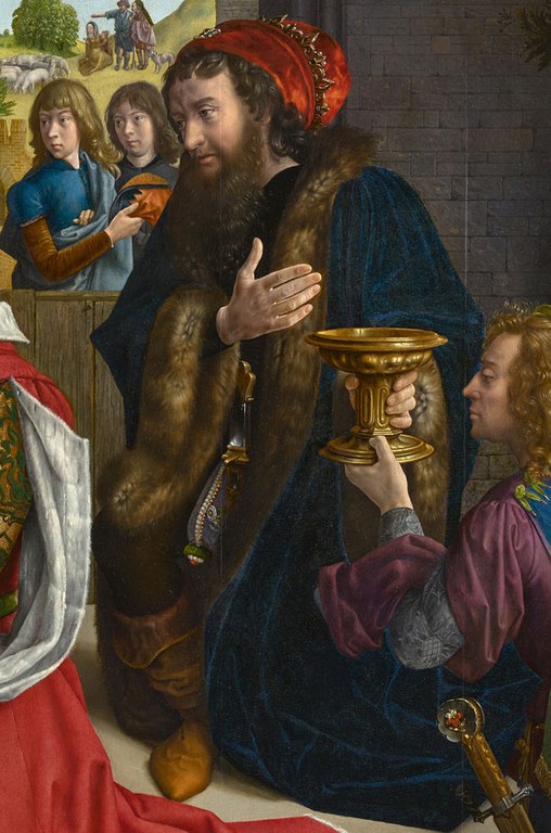 Ein bärtiger Mann in dickem Pelzmantel nimmt einem knienden Mann einen goldenen Kelch ab.