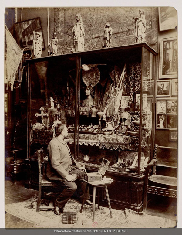 Edmond Bénard, Der Maler Albert Maignan vor einer Vitrine mit Objekten seiner Sammlung, ca. 1890, Paris, Bibliothèque de l’INHA, Fol Phot 039 (01), Foto: https://bibliotheque-numerique.inha.fr/idurl/1/15441]