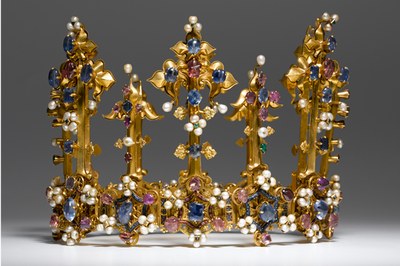 Foto einer goldenen Krone. Die Krone ist mit teuren Materialien wie Edelsteinen und Diamanten